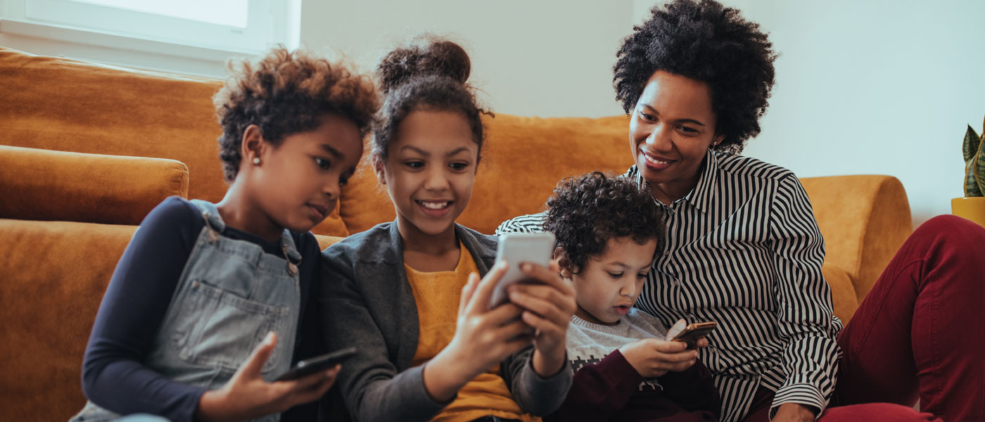 Black family enjoying digital devices